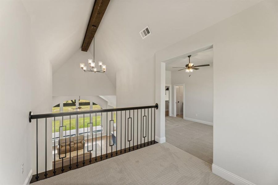 Hall with an inviting chandelier, beamed ceiling, light colored carpet, and high vaulted ceiling