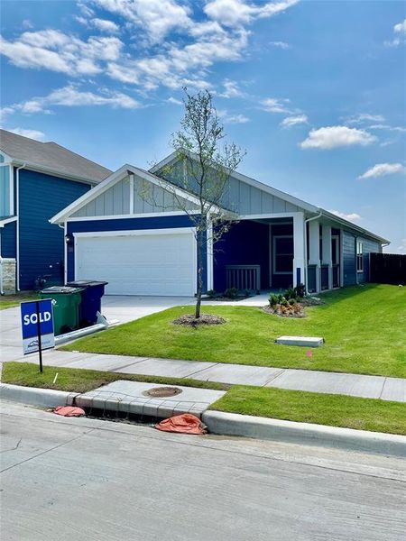 Single story home with a garage and a front yard