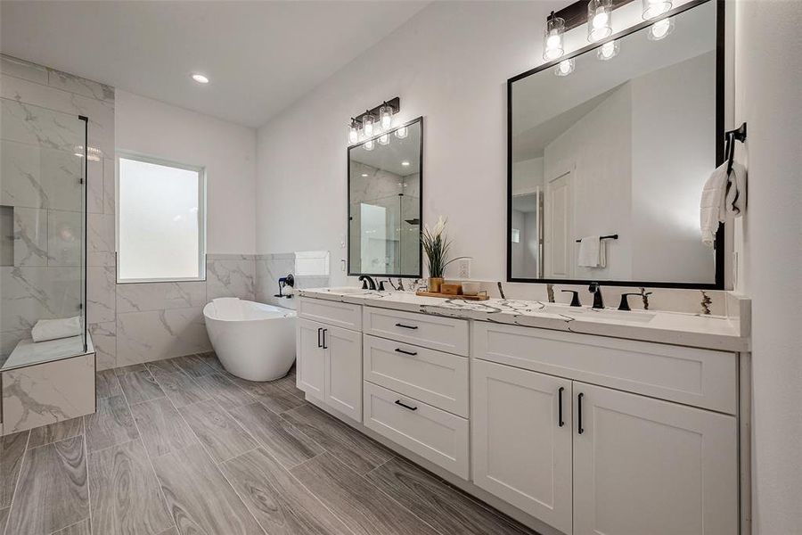 Primary Ensuite, custom features quartz countertops, soft close cabinets and drawers with black matte hardware and ceramic tile.