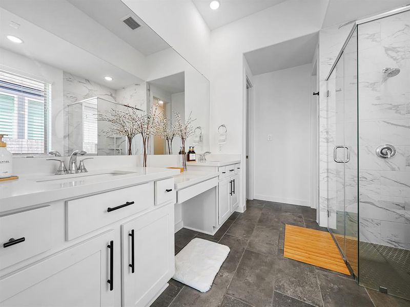 This stunning space features an extended vanity that offers ample storage, ensuring all your essentials are neatly organized and easily accessible. The luxurious quartz countertops not only elevate the aesthetic with their sleek and polished finish but also provide durability and easy maintenance.