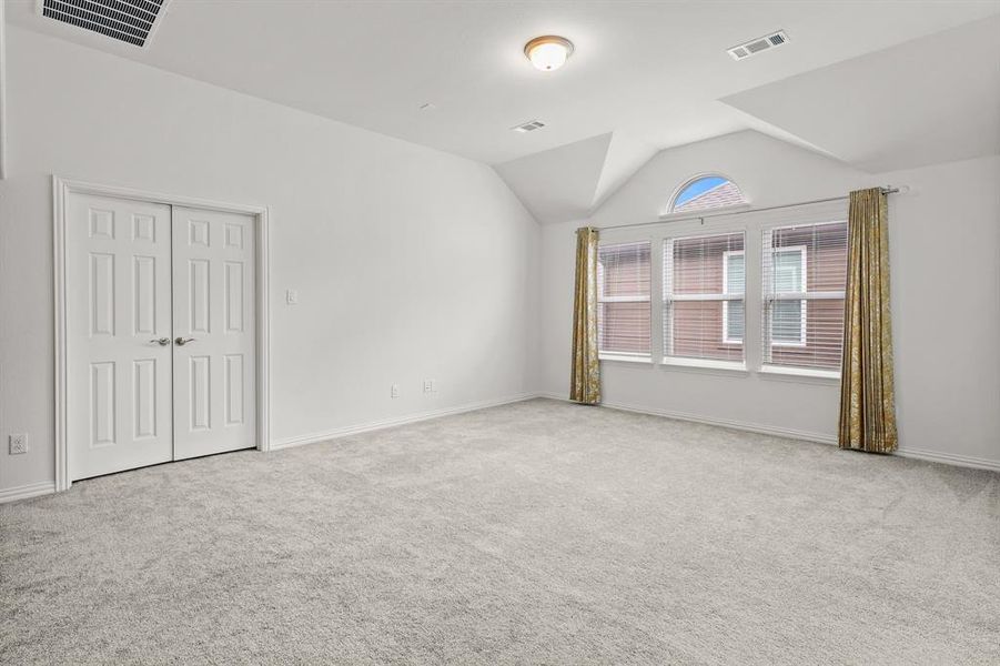 Carpeted empty room with lofted ceiling