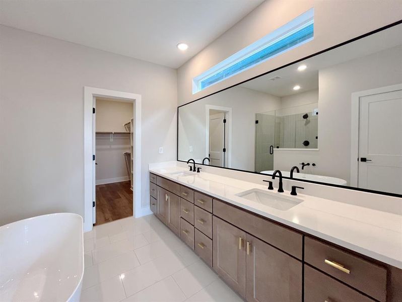 Elegant Ensuite: Featuring a sleek double vanity, modern fixtures, and a luxurious soaking tub, this master bathroom blends functionality with spa-like tranquility.