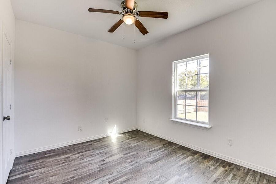 Empty room featuring ceiling fan and hardwood / wood-style floors