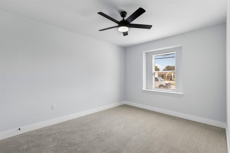 Carpeted spare room featuring ceiling fan