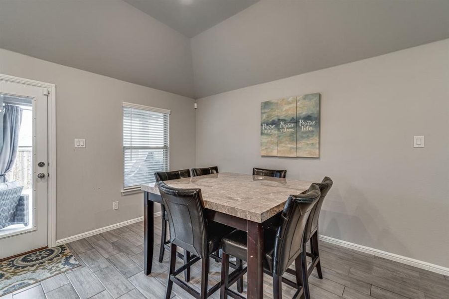 Dining room featuring lofted ceiling and hardwood / wood-style flooring