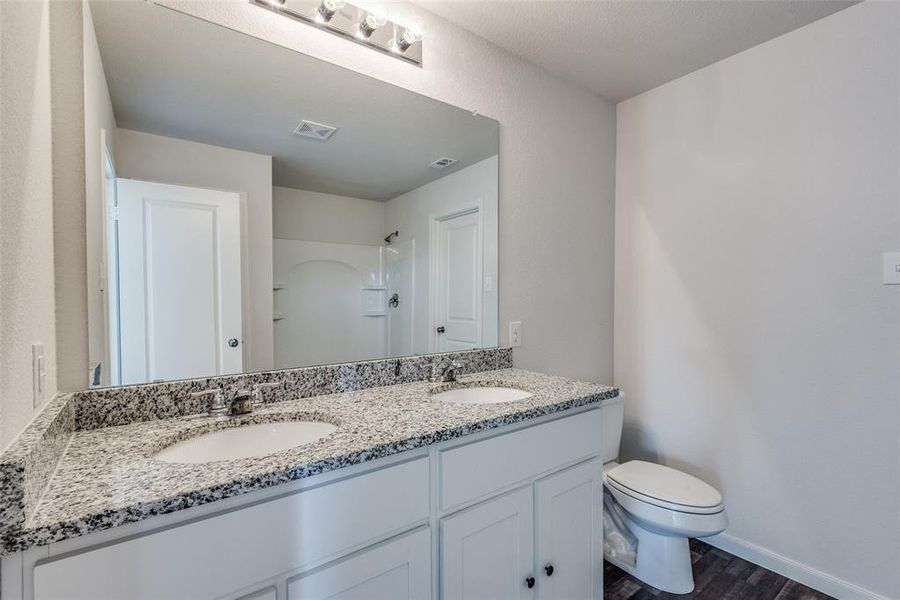 Bathroom with hardwood / wood-style flooring, vanity, and toilet