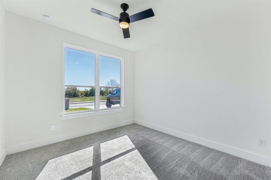 Unfurnished room with ceiling fan and carpet