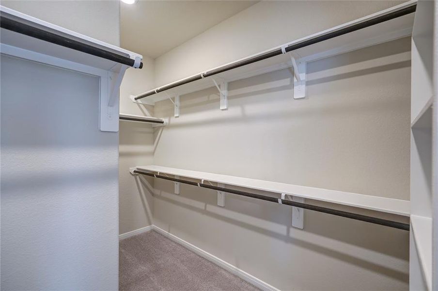 The walk-in closet offers multiple shelves and hanging rods for ample storage space.