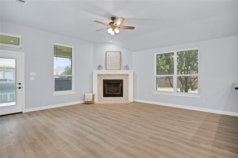 Living room featuring recessed lighting, light laminate wood-style floors, a wealth of natural light, ceiling fan and access to back patio overlooking the private backyard.