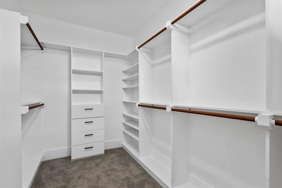 Walk in closet with dark colored carpet