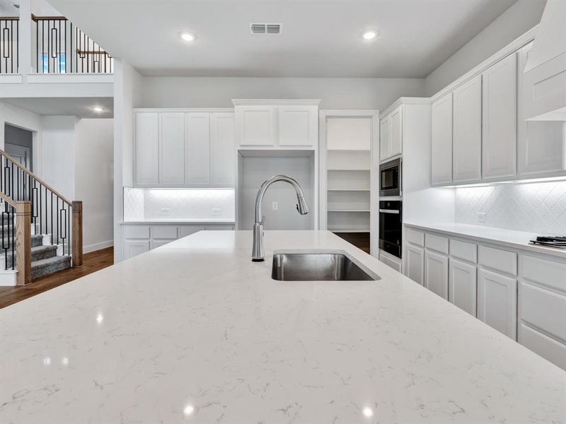 Kitchen featuring white cabinetry, decorative backsplash, and dark wood-type flooring