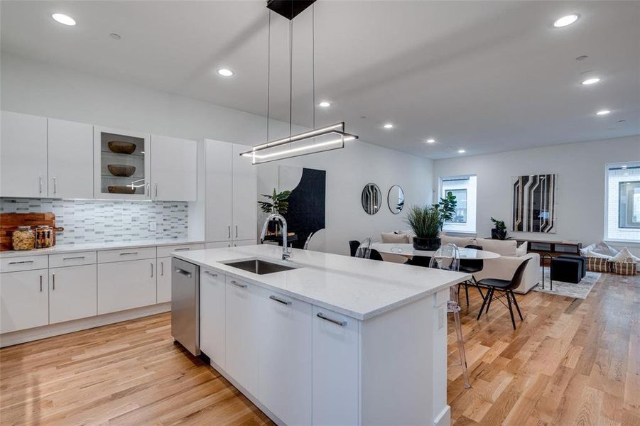 Kitchen with a healthy amount of sunlight, white cabinetry, and decorative light fixtures