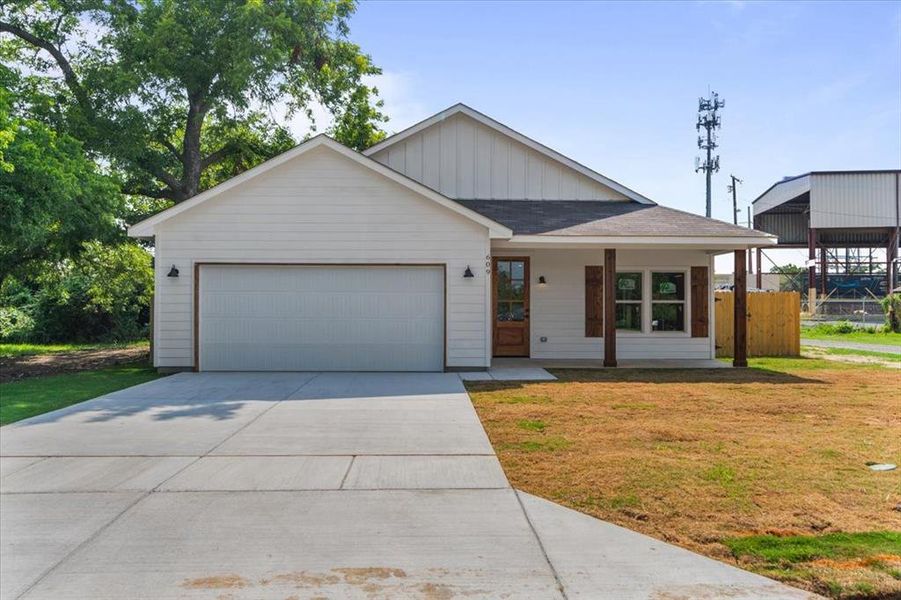 View of front of house featuring a garage and a front yard