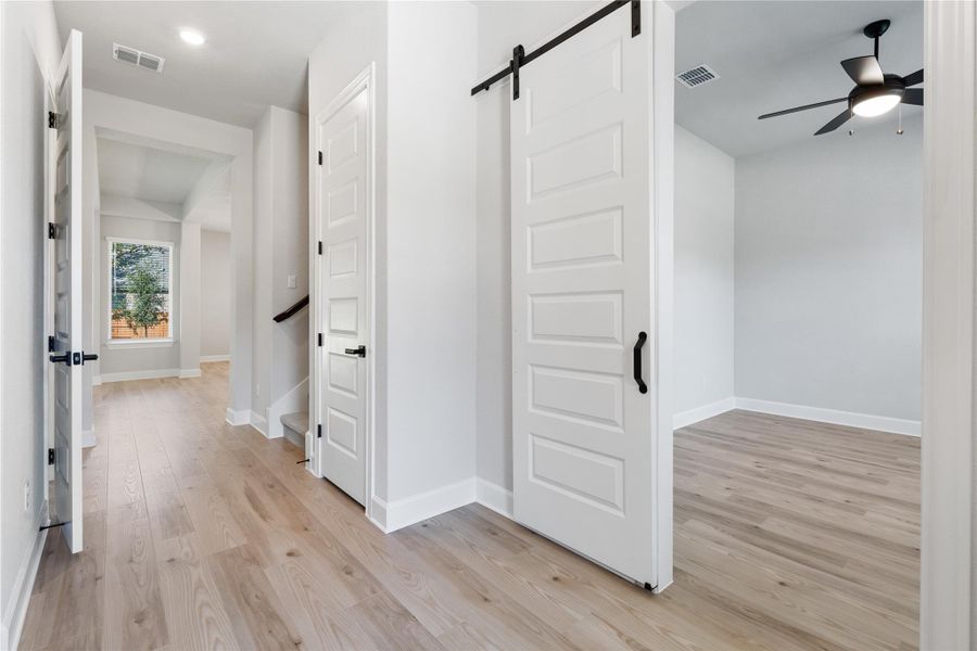 Enter the office/flex room through an elegant sliding barn door.