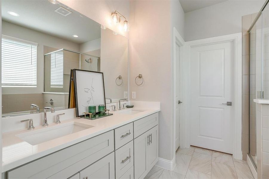 Bathroom with a shower with shower door and vanity