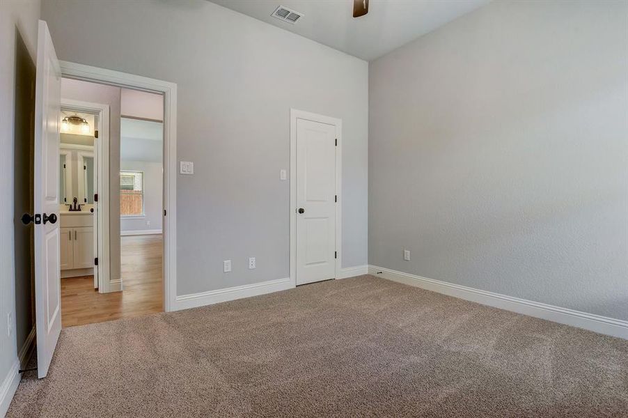 Unfurnished bedroom featuring sink, carpet, and ceiling fan