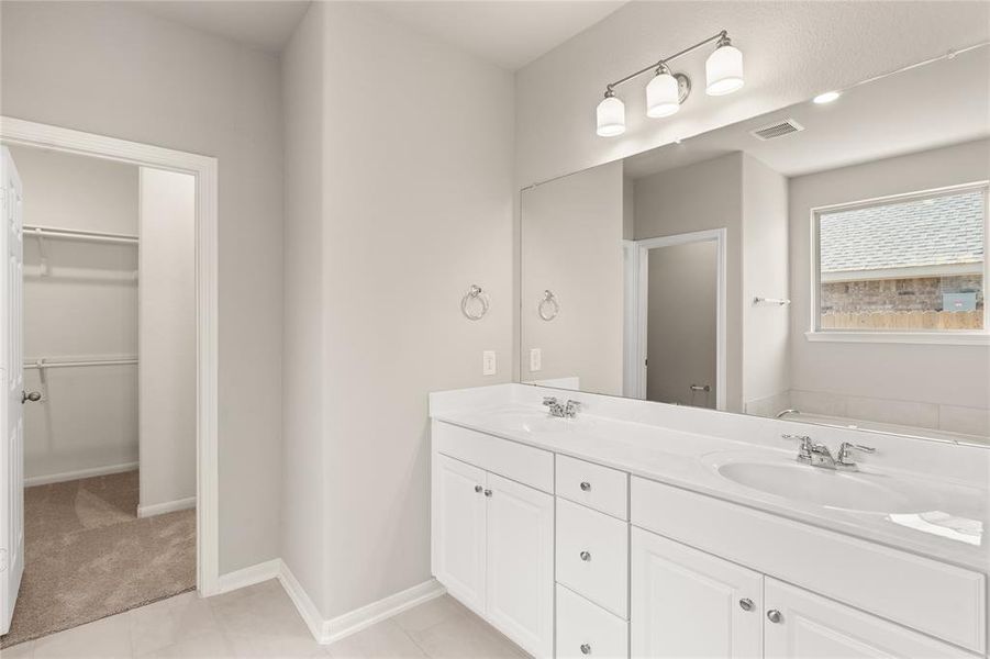 The en-suite bathroom offers a spa-like atmosphere with its elegant design, high end finishes, and tasteful lighting, creating a retreat within your own home.