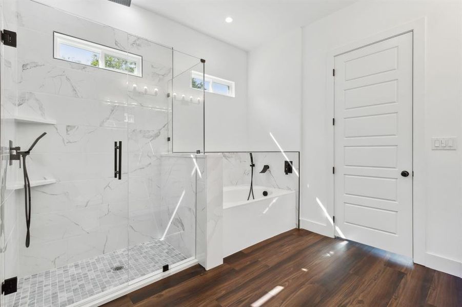 Bathroom with shower with separate bathtub and hardwood / wood-style floors