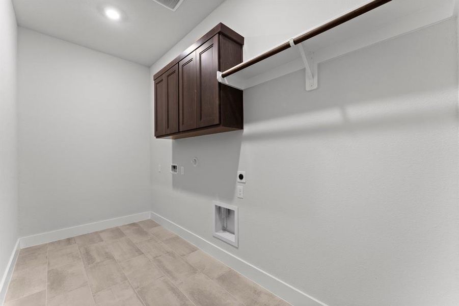 Utility Room with Washer and Dryer Connections, Hanging Bar, and Storage.