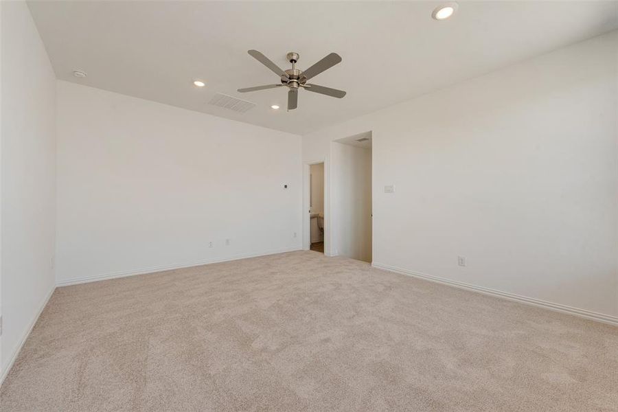 Empty room with ceiling fan and light colored carpet