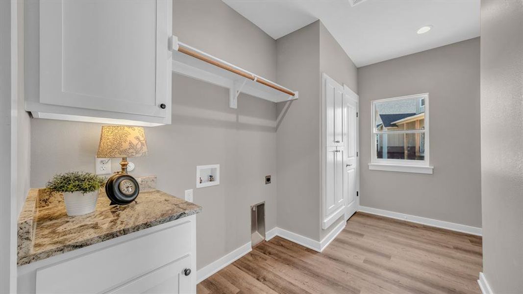 Laundry room with hookup for an electric dryer & washer.  Built-ins, storage closet & room for freezer