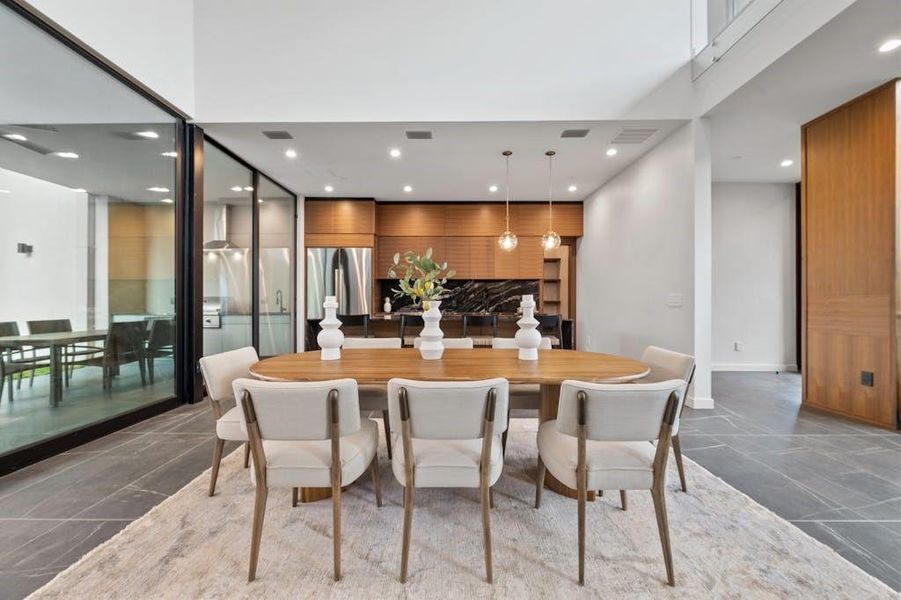 This inviting space showcases a modern, well-equipped kitchen seamlessly integrated with a stylish dining area. Gleaming countertops, sleek cabinetry, and state-of-the-art appliances create a culinary environment that is both aesthetically pleasing and highly functional.