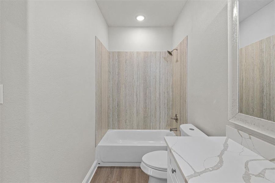 Full bathroom with vanity, shower / bathing tub combination, hardwood / wood-style flooring, and toilet