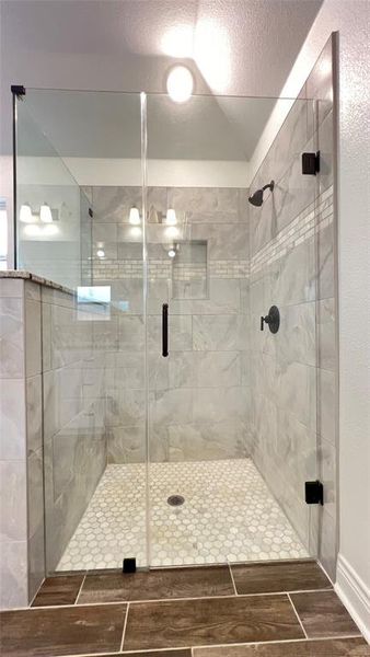 Bathroom with a textured ceiling and a shower with door