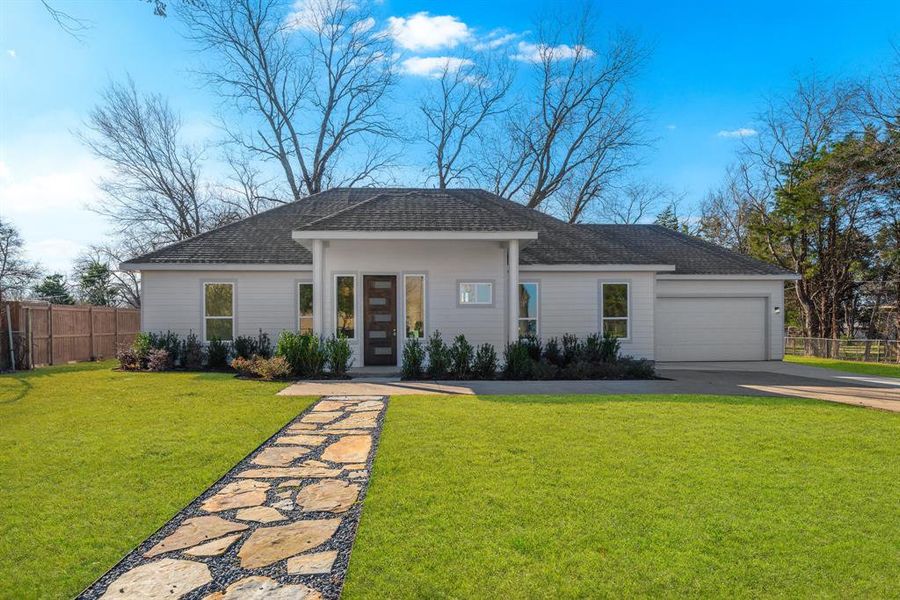 Single story home with a garage and a front lawn