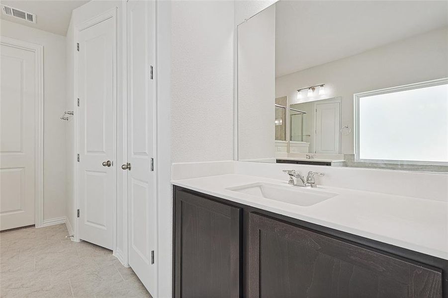 Bathroom featuring vanity and a shower with shower door