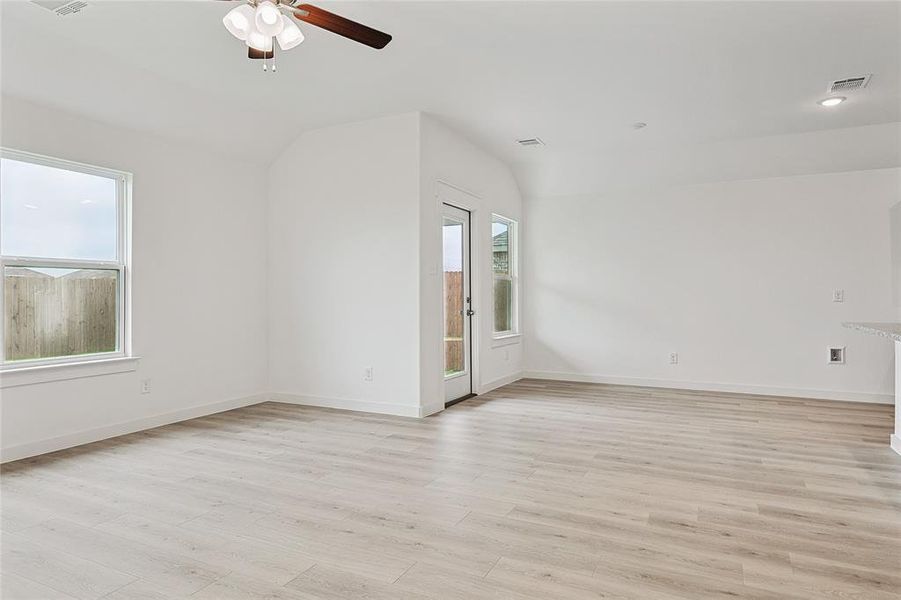 Spare room featuring lofted ceiling, light hardwood / wood-style flooring, and ceiling fan