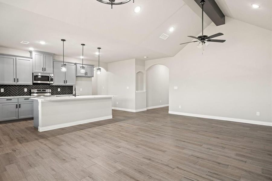 Kitchen with ceiling fan, stainless steel appliances, gray cabinets, and light wood-type flooring