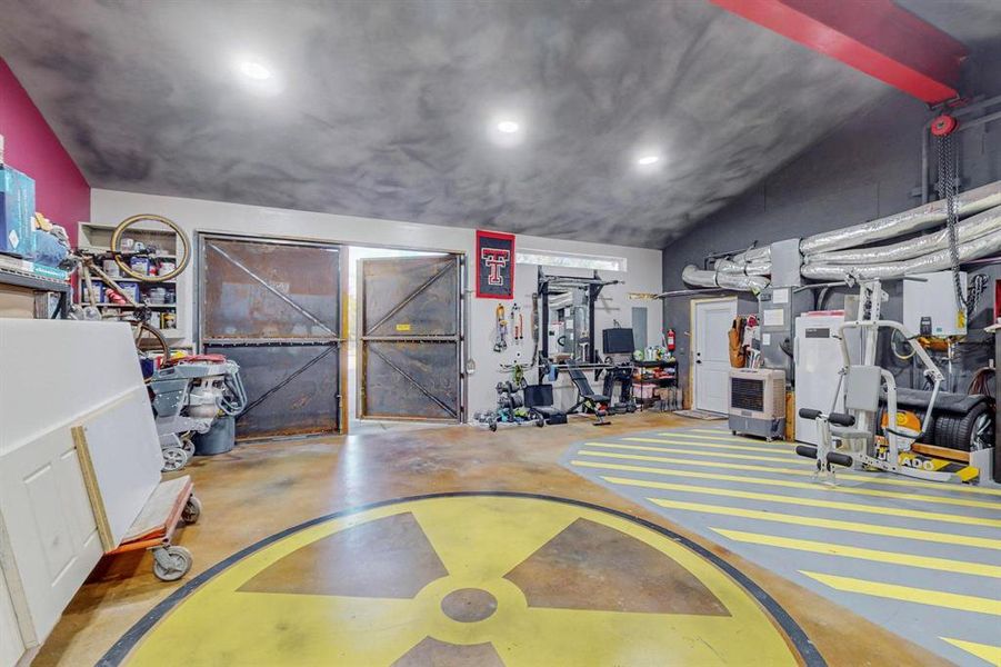 Gym featuring lofted ceiling and concrete flooring