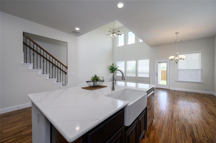 Kitchen featuring plenty of natural light, dark wood-type flooring, and an island with sink