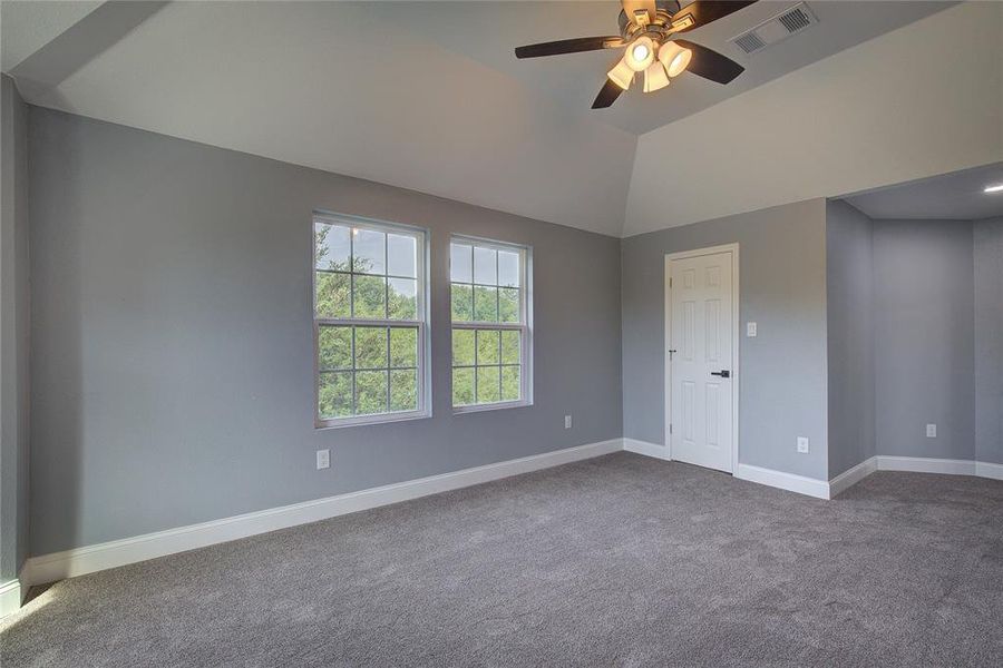 Bedroom 2 with vaulted ceiling, ceiling fan, and carpet flooring