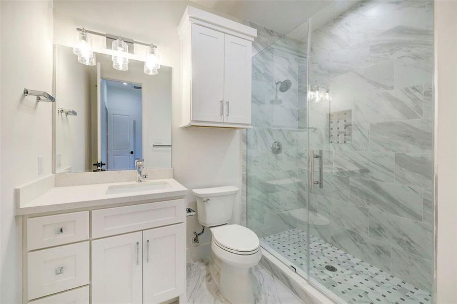 SAMPLE - Secondary bath features Calcatta Quartz countertops and walk-in shower with fully tiled marble enclosure to the ceiling.