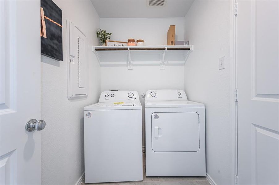 Washroom featuring light tile patterned flooring and separate washer and dryer