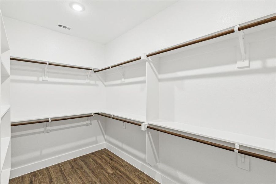 Walk in closet with dark hardwood / wood-style flooring