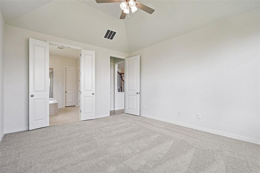 Unfurnished bedroom featuring high vaulted ceiling, ceiling fan, and light colored carpet