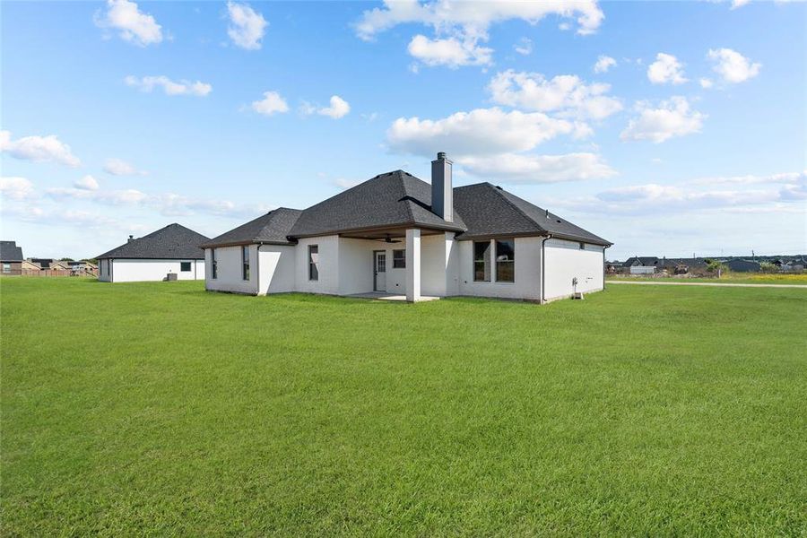 Back of property featuring a patio and a lawn