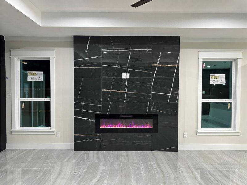 Room details featuring a large electric fireplace and porcelain high gloss tile floors