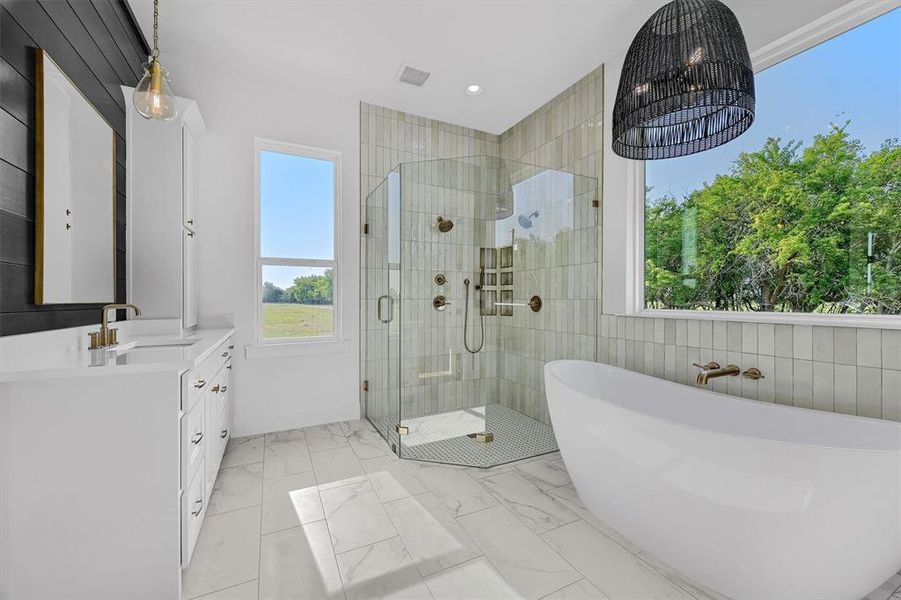 Bathroom featuring plus walk in shower, vanity, and tile patterned flooring