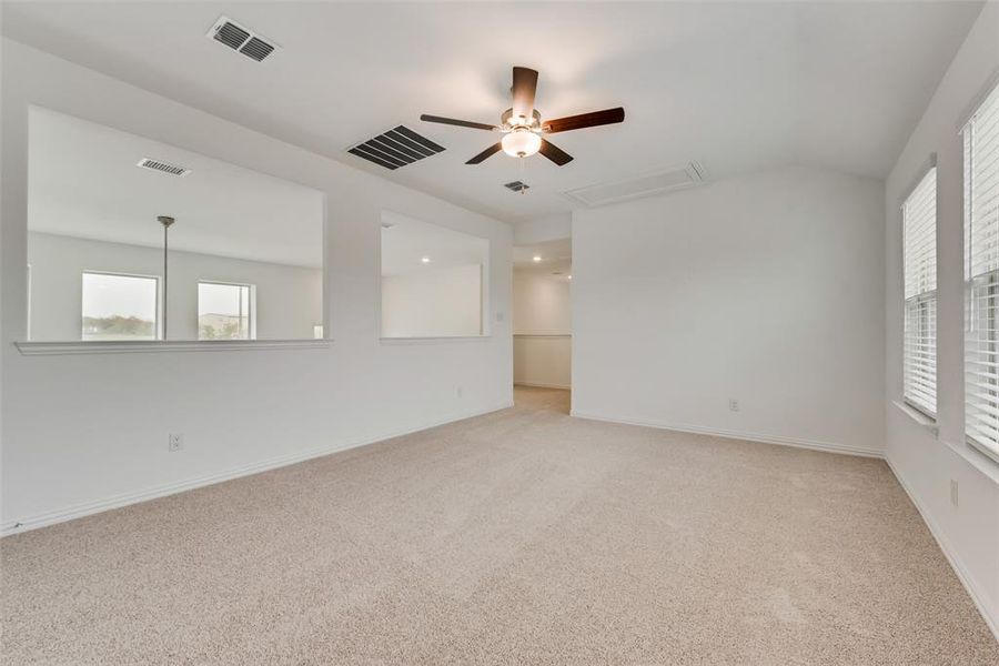 Unfurnished room featuring vaulted ceiling, ceiling fan, and carpet flooring