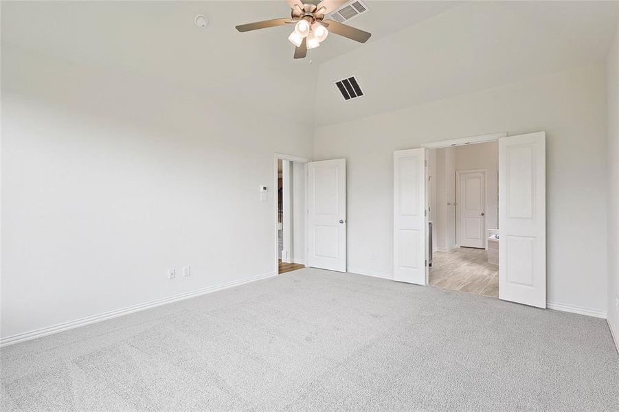 Unfurnished bedroom with high vaulted ceiling, carpet, and ceiling fan