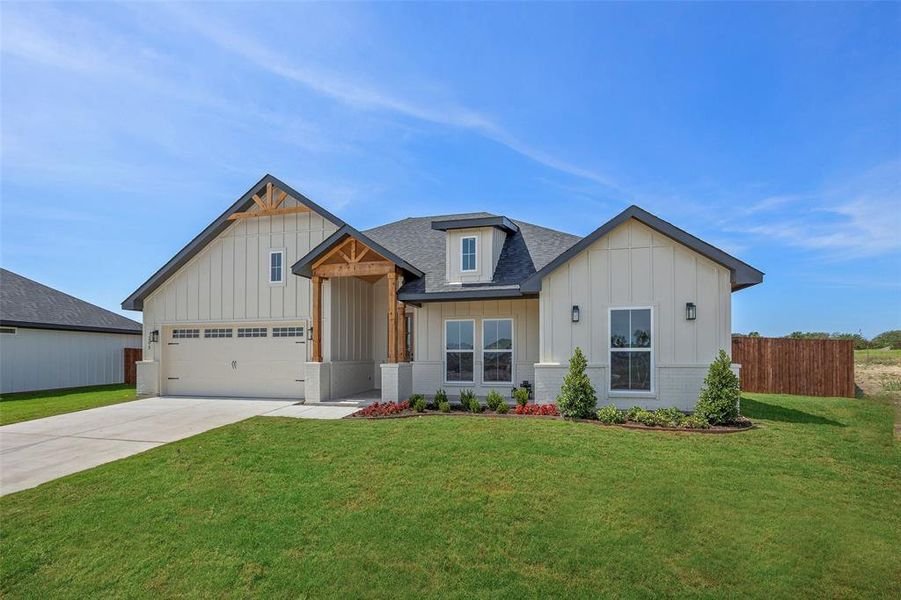 View of front of house with a garage and a front lawn