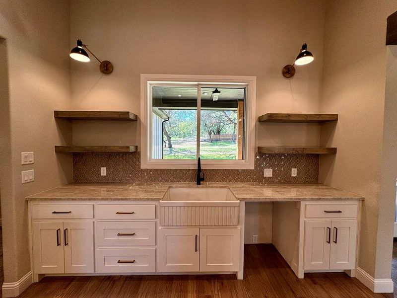 Kitchen with tasteful backsplash, sink, dark hardwood / wood-style flooring, and white cabinetry