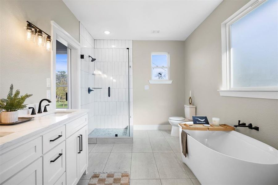 Full bathroom featuring toilet, independent shower and bath, vanity, and tile patterned flooring