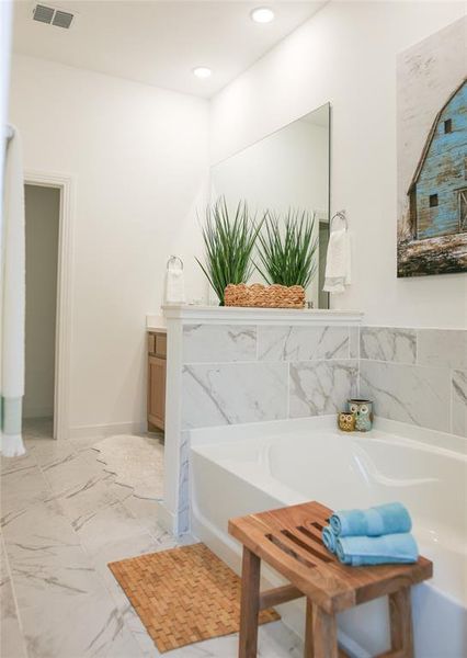 Bathroom featuring vanity, a washtub, and tile patterned floors