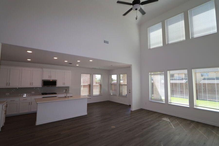 Kitchen with white cabinetry, plenty of natural light, and an island with sink