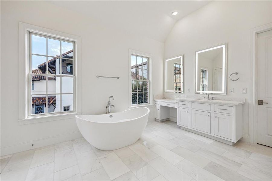 Primary bath with dual sinks, vanity, soaking tub and stand alone shower.